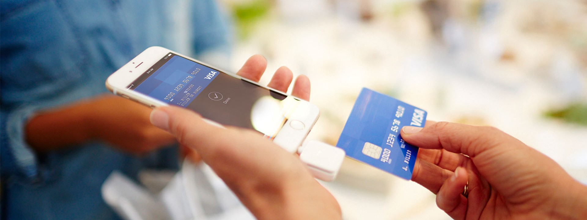 Woman handing off Visa Card to merchant