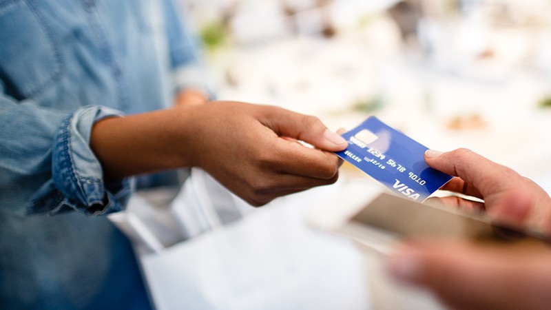 Woman handing off Visa Card to merchant